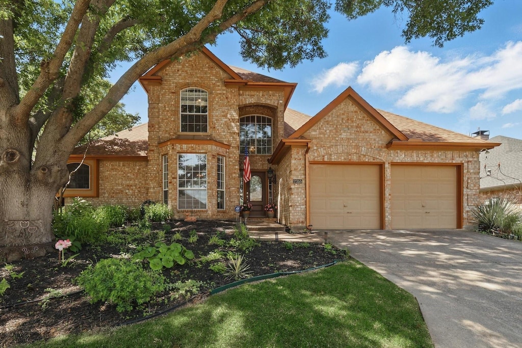 2355 Glen Ridge Dr, Highland Village, TX 75077 - traditional-style house featuring brick siding, a garage, concrete driveway, and a shingled roof