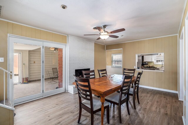 1809 Esquire Pl, Grand Prairie, TX 75050 - dining room with a ceiling fan, wood finished floors, crown molding, a fireplace, and baseboards