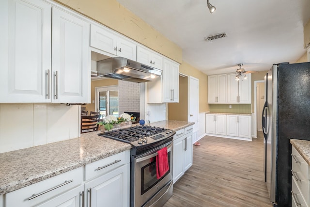 1809 Esquire Pl, Grand Prairie, TX 75050 - kitchen with stainless steel appliances, under cabinet range hood, white cabinets, light wood-style flooring, and ceiling fan
