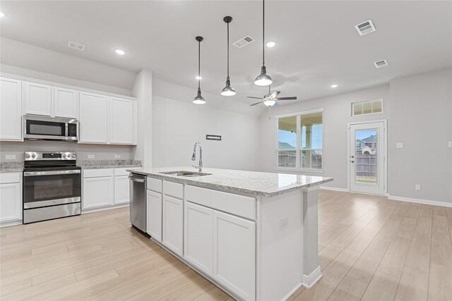 3625 Beutel Rd, Waco, TX 76655 - kitchen featuring appliances with stainless steel finishes, a sink, light wood-type flooring, ceiling fan, and white cabinets