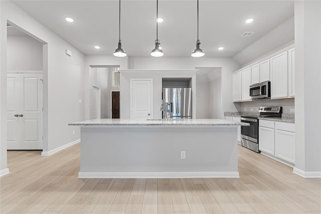 3625 Beutel Rd, Waco, TX 76655 - kitchen featuring appliances with stainless steel finishes, white cabinets, an island with sink, light wood finished floors, and recessed lighting