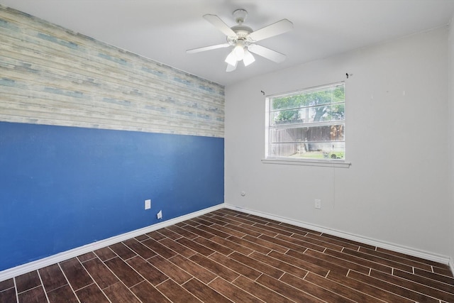 6529 Wooddale Dr, Watauga, TX 76148 - empty room with an accent wall, baseboards, ceiling fan, and wood finished floors