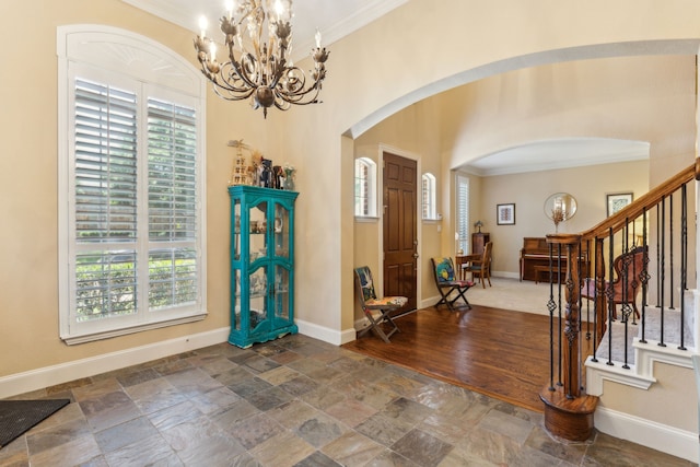 701 Mason Dr, Allen, TX 75013 - foyer entrance with arched walkways, ornamental molding, a chandelier, stone tile flooring, and stairs