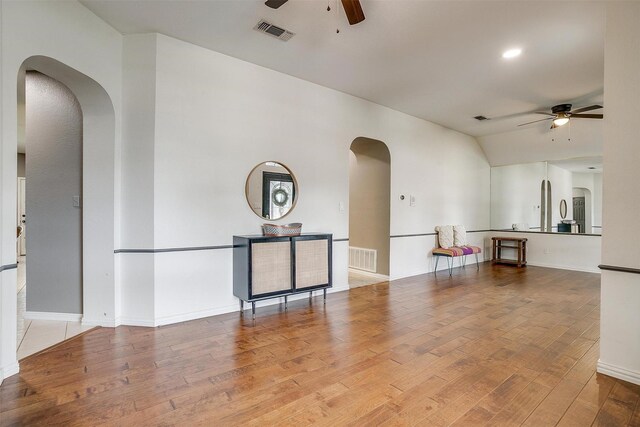 1100 Highcrest Dr, Burleson, TX 76028 - unfurnished living room featuring ceiling fan, arched walkways, wood finished floors, baseboards, and lofted ceiling