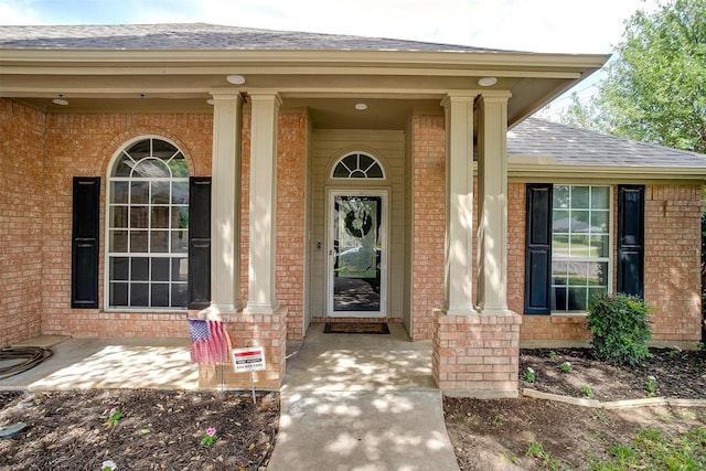 1100 Highcrest Dr, Burleson, TX 76028 - view of exterior entry with brick siding, a shingled roof, and a porch