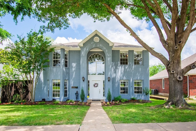 8200 Edgewater Dr, Frisco, TX 75034 - view of front of home featuring brick siding, a front lawn, and central AC unit