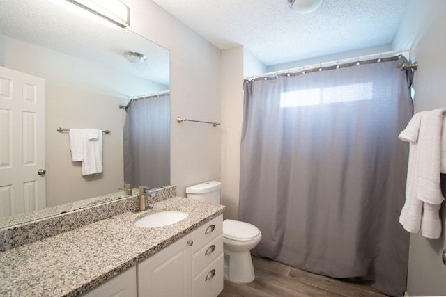 8200 Edgewater Dr, Frisco, TX 75034 - bathroom featuring wood finished floors, vanity, toilet, a textured ceiling, and a shower with curtain
