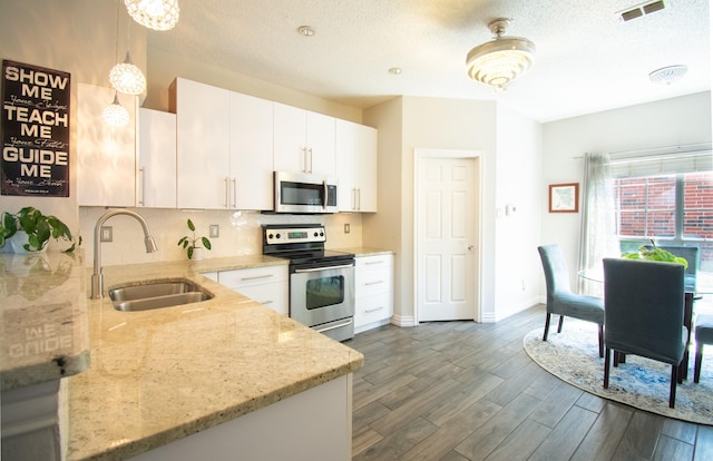 8200 Edgewater Dr, Frisco, TX 75034 - kitchen with appliances with stainless steel finishes, a sink, dark wood-type flooring, light stone counters, and backsplash