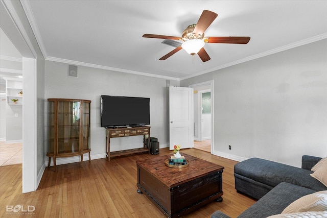 living area featuring ornamental molding, ceiling fan, wood finished floors, and baseboards