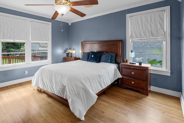 bedroom with baseboards, wood finished floors, ornamental molding, and ceiling fan