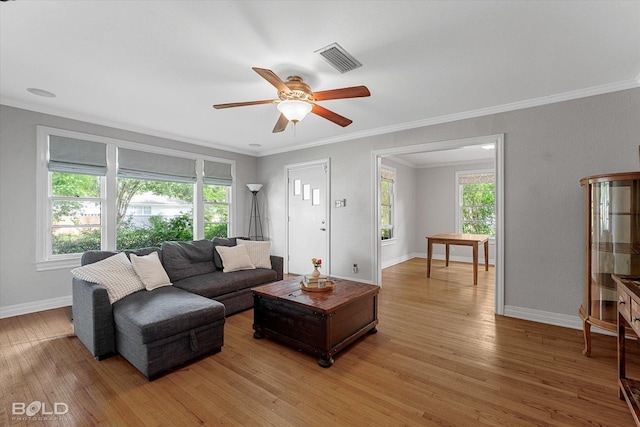 living room with a ceiling fan, light wood finished floors, baseboards, and ornamental molding