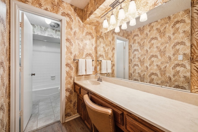 731 N Horne St, Duncanville, TX 75116 - bathroom featuring wallpapered walls, vanity, wood finished floors, toilet, and shower / bathtub combination