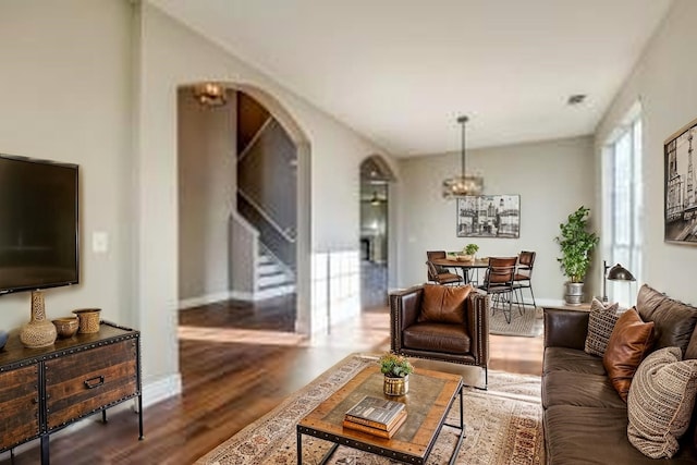 2789 Coyote Trl, Little Elm, TX 75068 - living room featuring arched walkways, a chandelier, wood finished floors, and baseboards