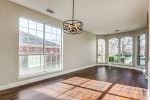 2789 Coyote Trl, Little Elm, TX 75068 - unfurnished dining area with baseboards, dark wood finished floors, and a chandelier