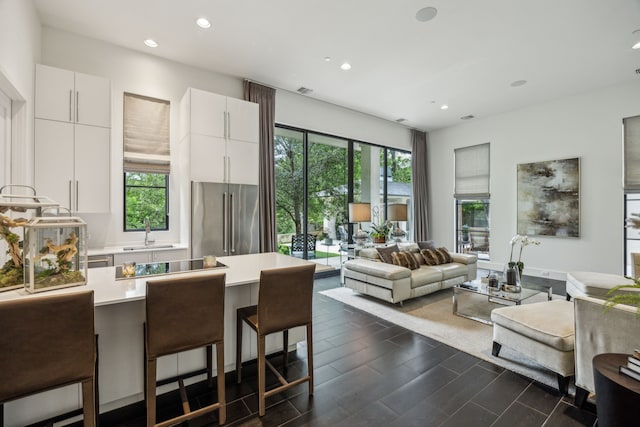 5214 Royal Ln, Dallas, TX 75229 - kitchen featuring high end refrigerator, a kitchen bar, healthy amount of natural light, light countertops, and recessed lighting