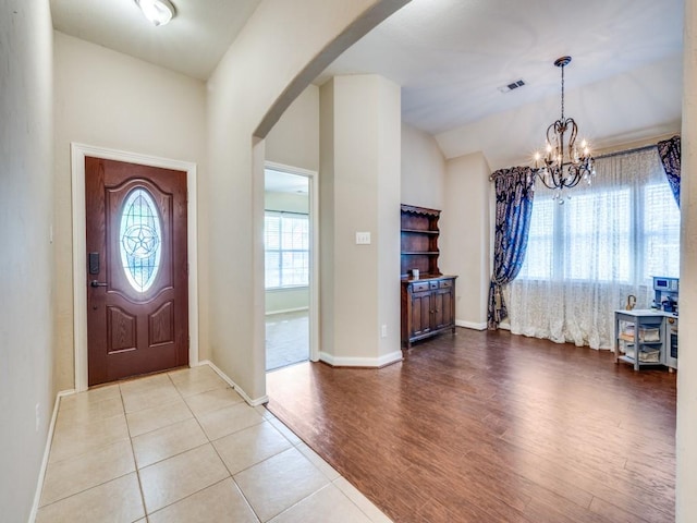 1209 Golden Eagle Ct, Aubrey, TX 76227 - foyer entrance with a chandelier, arched walkways, wood finished floors, vaulted ceiling, and baseboards