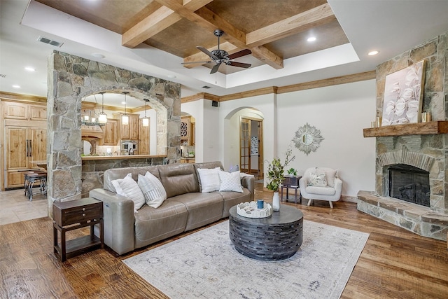 4312 Tapatio Springs Rd, Fort Worth, TX 76108 - living area featuring coffered ceiling, arched walkways, a ceiling fan, a stone fireplace, and beam ceiling
