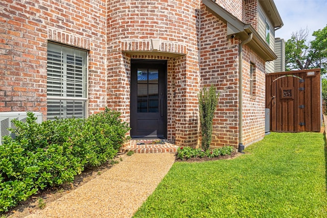 6137 Oram St, Dallas, TX 75214 - view of exterior entry featuring brick siding, a lawn, a gate, and a cooling unit
