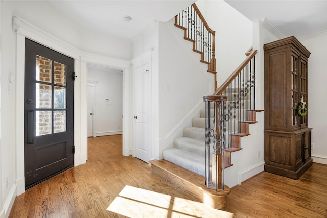 6137 Oram St, Dallas, TX 75214 - foyer entrance with light wood-style flooring, stairway, ornamental molding, and baseboards