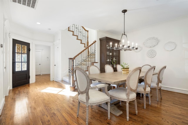 6137 Oram St, Dallas, TX 75214 - dining area featuring stairway, wood finished floors, baseboards, a chandelier, and ornamental molding