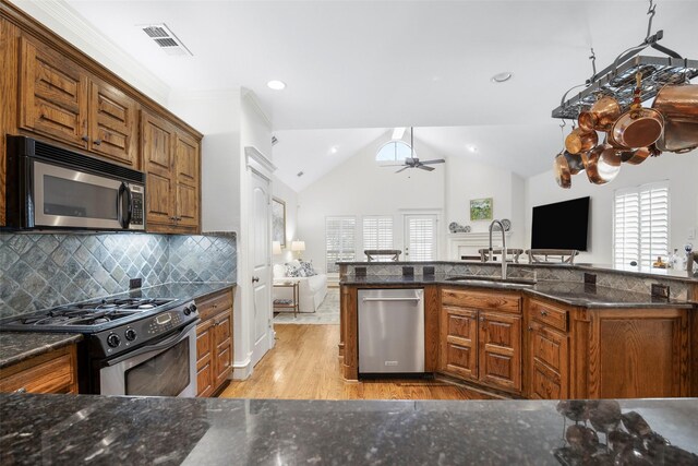 6137 Oram St, Dallas, TX 75214 - kitchen featuring stainless steel appliances, a sink, open floor plan, light wood-type flooring, and vaulted ceiling