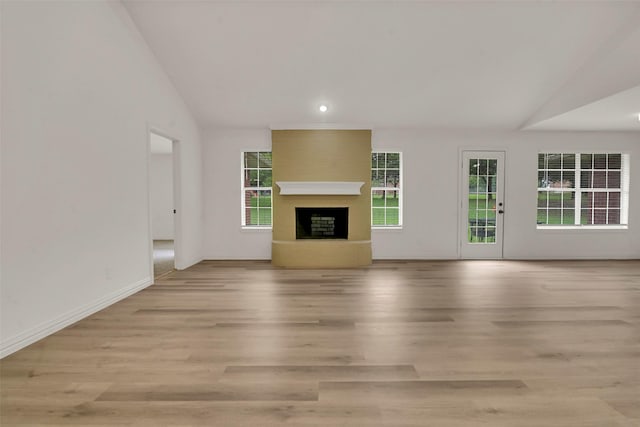 289 Cates Rd, Van Alstyne, TX 75495 - unfurnished living room with vaulted ceiling, a fireplace with raised hearth, light wood finished floors, and recessed lighting
