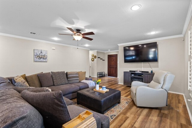 living area with recessed lighting, a ceiling fan, wood finished floors, baseboards, and ornamental molding