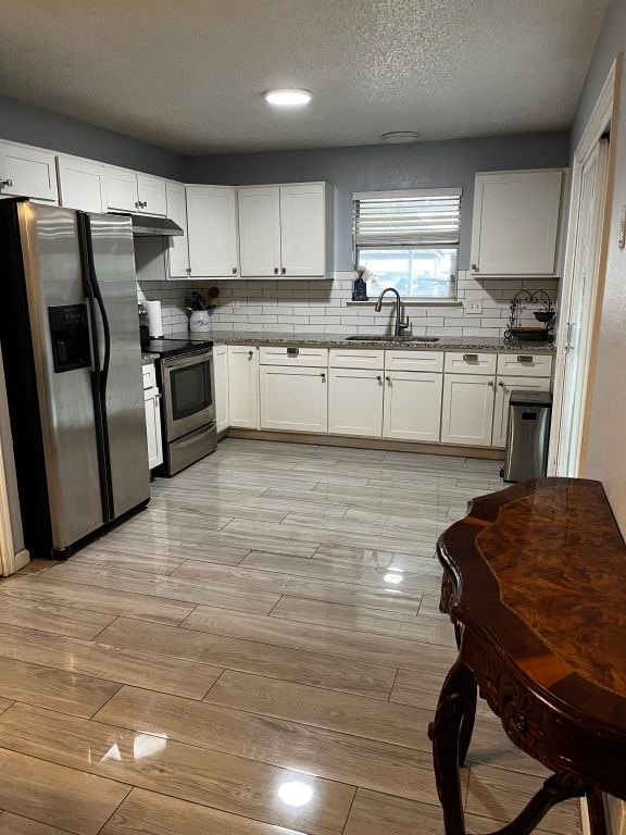 kitchen featuring appliances with stainless steel finishes, a sink, light wood-type flooring, tasteful backsplash, and recessed lighting