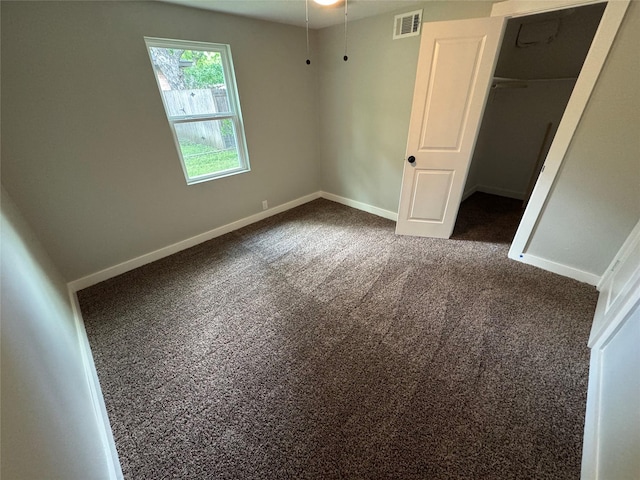 1220 Brittany Ln, Arlington, TX 76013 - unfurnished bedroom featuring dark colored carpet, baseboards, a walk in closet, and a closet