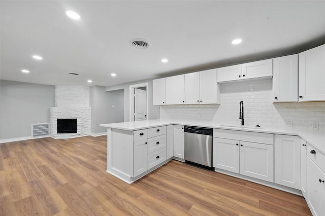 1220 Brittany Ln, Arlington, TX 76013 - kitchen with stainless steel dishwasher, a sink, light countertops, a peninsula, and white cabinets