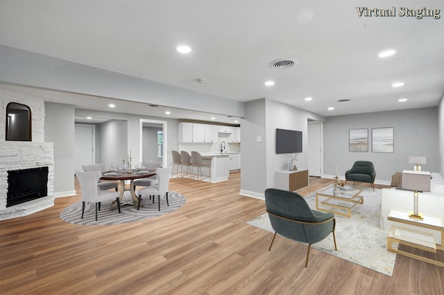 1220 Brittany Ln, Arlington, TX 76013 - living area with light wood-type flooring, a fireplace, baseboards, and recessed lighting