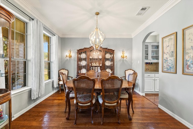 227 Justin Rd, Murphy, TX 75094 - dining room featuring dark wood-type flooring, a chandelier, arched walkways, ornamental molding, and baseboards