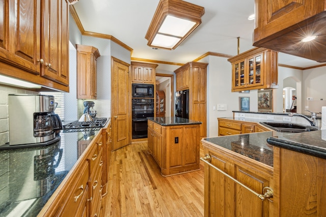 4024 Oakmeadow Dr, Plano, TX 75093 - kitchen featuring black appliances, a sink, crown molding, light wood-style flooring, and a center island