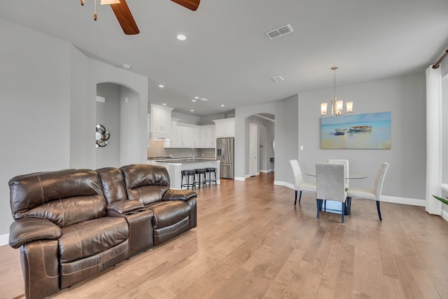14937 Belclaire Ave, Aledo, TX 76008 - living area featuring arched walkways, ceiling fan, a chandelier, light wood-style flooring, and baseboards