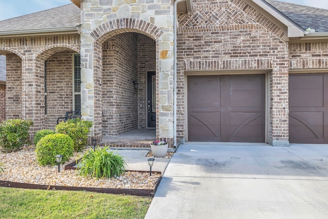 14937 Belclaire Ave, Aledo, TX 76008 - view of exterior entry with driveway, brick siding, an attached garage, and roof with shingles