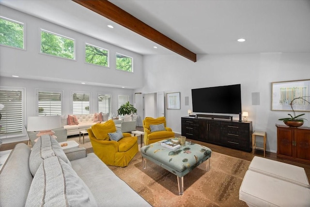 living area featuring beamed ceiling, recessed lighting, a towering ceiling, and wood finished floors