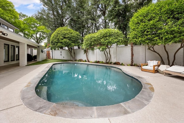 view of pool with a fenced backyard and a patio