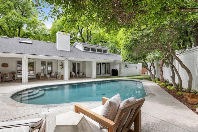 swimming pool with outdoor lounge area, a patio area, and fence