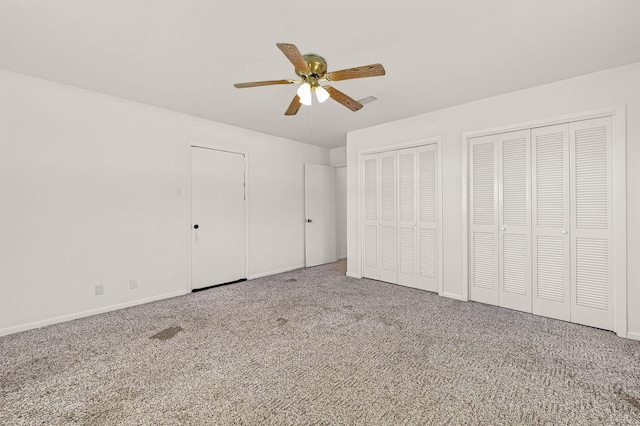unfurnished bedroom with multiple closets, carpet floors, baseboards, and ceiling fan