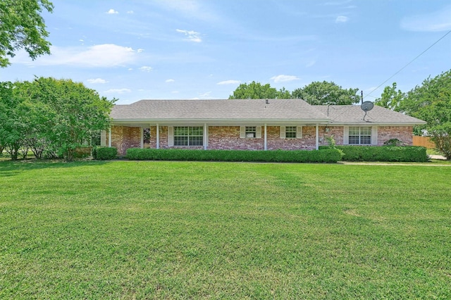 ranch-style home featuring a front lawn, roof with shingles, and brick siding
