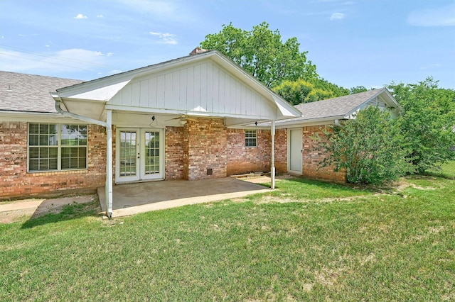 back of house featuring brick siding, a lawn, a shingled roof, and a ceiling fan