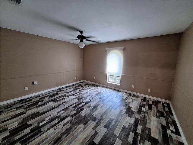 empty room featuring a ceiling fan, wood finished floors, and baseboards
