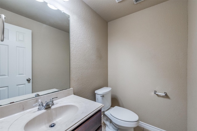 5844 Sunny Meadow Ln, Grand Prairie, TX 75052 - bathroom with a textured wall, toilet, vanity, a textured ceiling, and baseboards