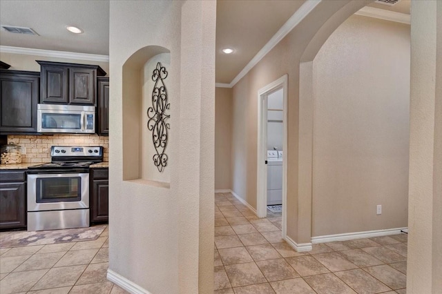 1823 Woodland Park Dr, Denison, TX 75021 - kitchen featuring stainless steel appliances, arched walkways, ornamental molding, decorative backsplash, and light tile patterned flooring