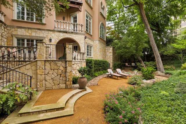 3725 Turtle Creek Blvd Unit A, Dallas, TX 75219 - view of exterior entry with a balcony, stucco siding, stone siding, and a patio
