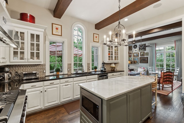 3725 Turtle Creek Blvd Unit A, Dallas, TX 75219 - kitchen with stainless steel appliances, a sink, beamed ceiling, backsplash, and a chandelier