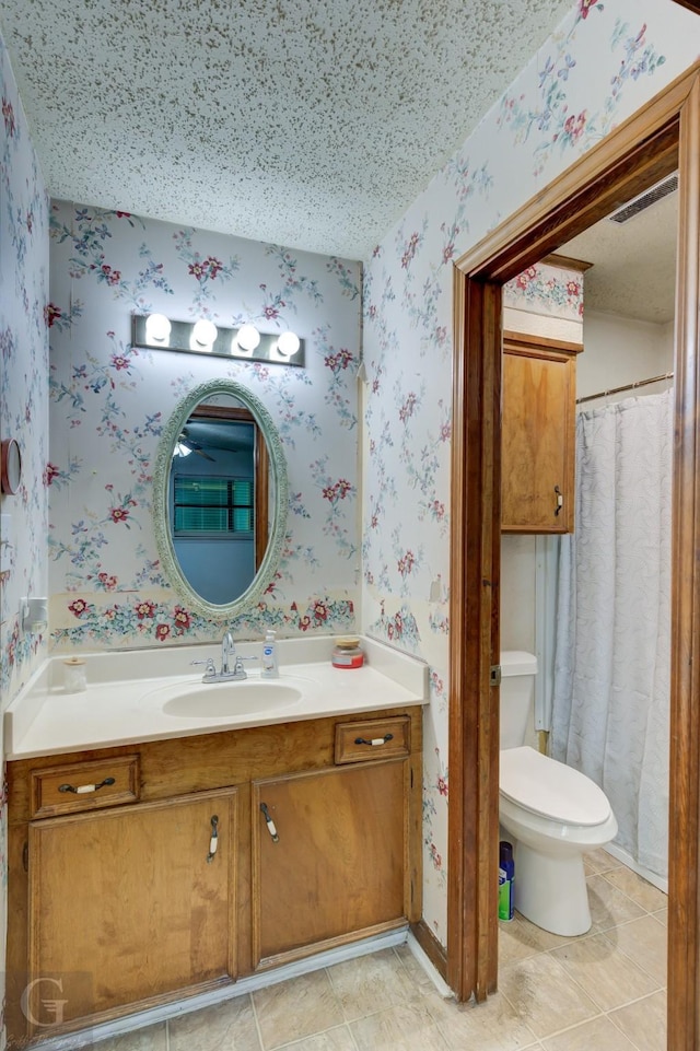 bathroom featuring wallpapered walls, vanity, and toilet
