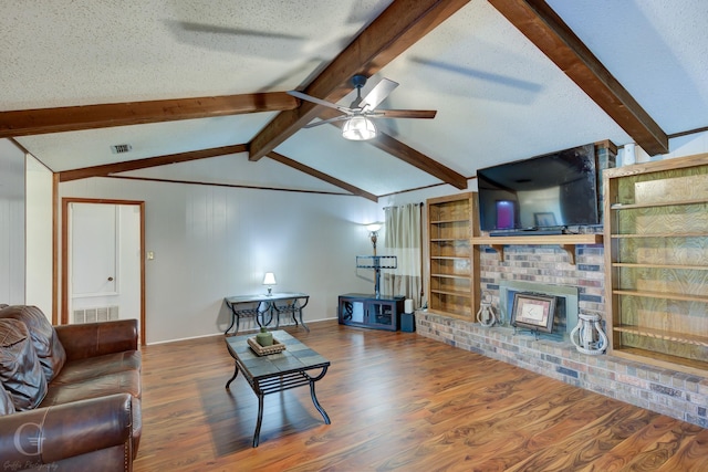 living room featuring a fireplace, wood finished floors, a ceiling fan, and a textured ceiling