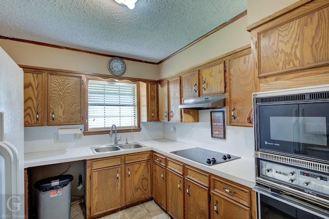 kitchen with black appliances, a sink, under cabinet range hood, a textured ceiling, and light countertops
