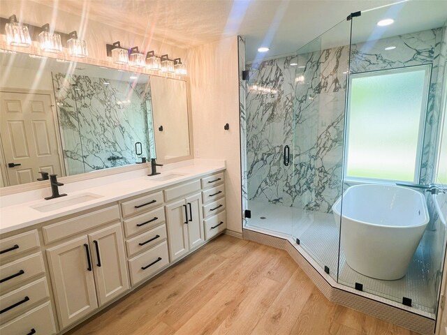 113 County Road 3198, Decatur, TX 76234 - bathroom featuring a marble finish shower, double vanity, wood finished floors, a freestanding tub, and recessed lighting